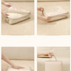 A set of beige compressible packing cubes being handled and shown in various angles on a light-colored surface.
