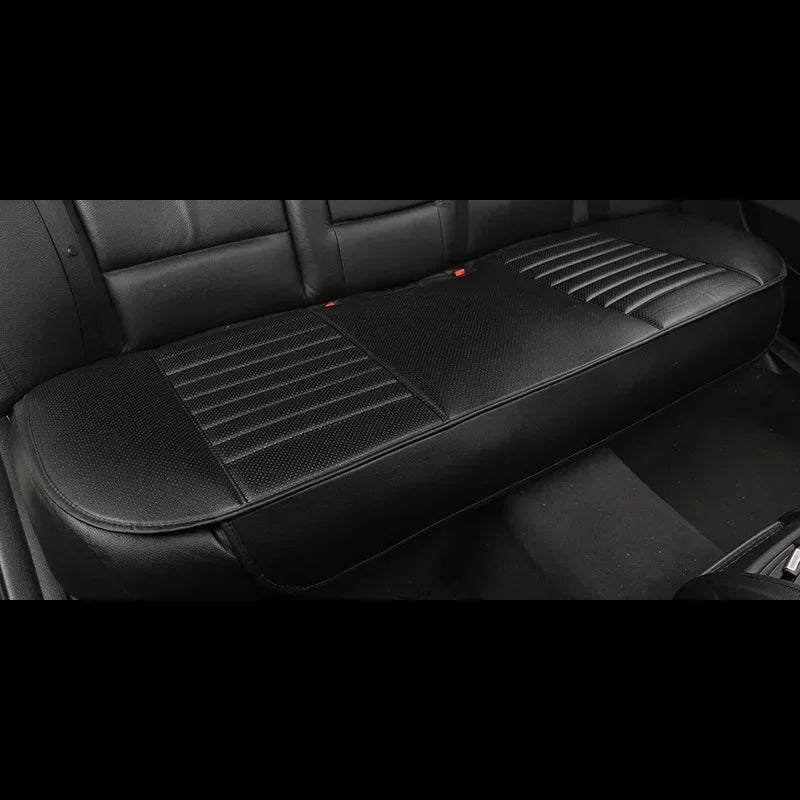 A close-up view of a black car seat cover featuring textured pleats and stitching.