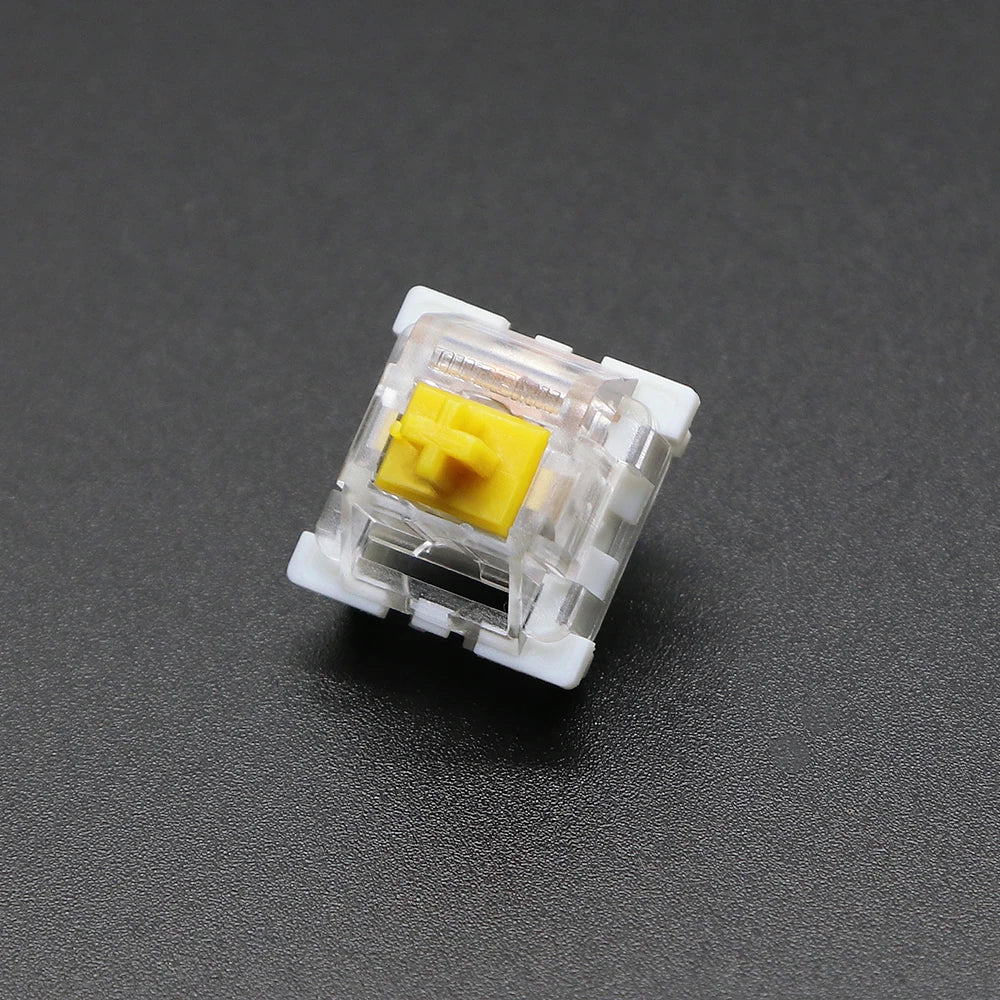 A close-up view of a white plastic mechanical keyboard switch with a yellow housing.