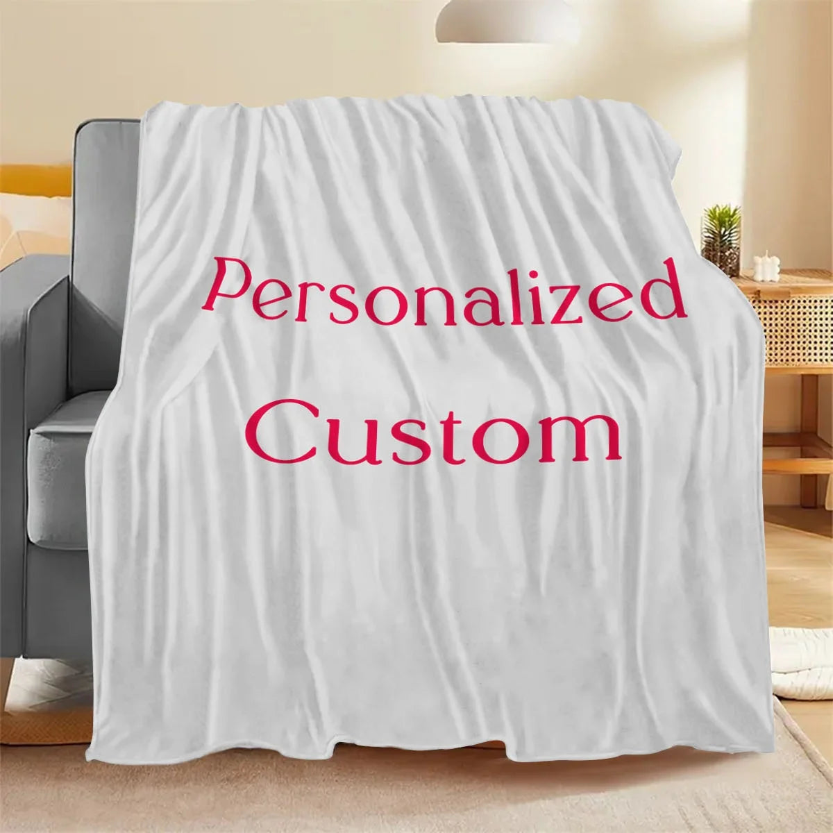 Weiße Stoffdecke über einem Stuhl, mit dem Text „Personalisiert Custom“ in rosa Schrift.
