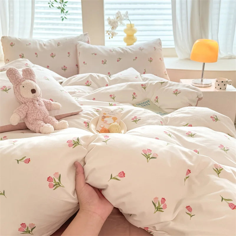 A set of cute dog print duvet cover and pillowcases in cream with pink floral accents.
