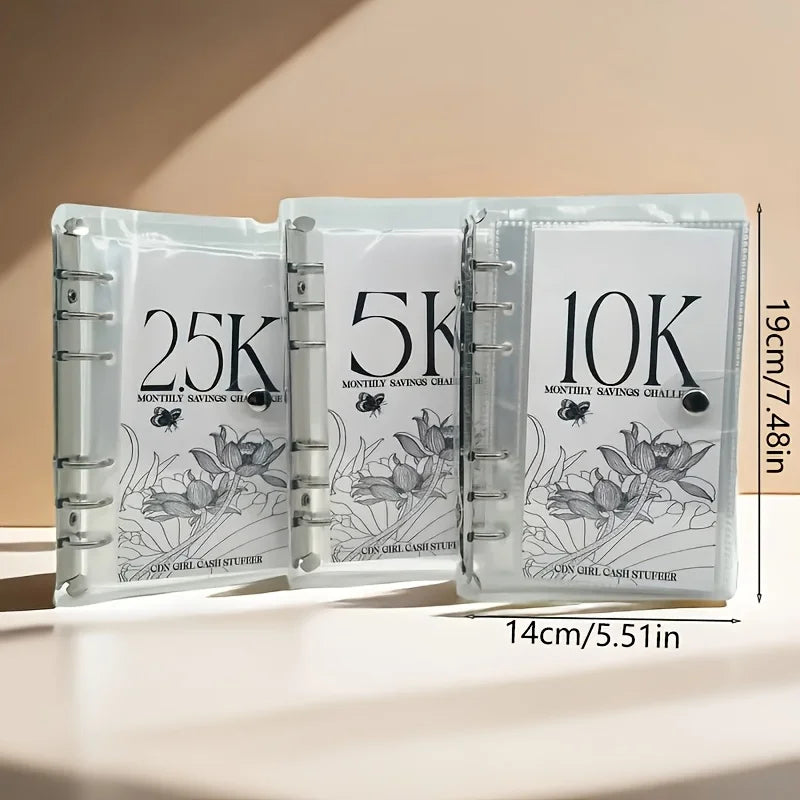 Set aus drei klaren Kunststoffordnern für monatliche Sparherausforderungen mit den Markierungen 25K, 5K und 10K.