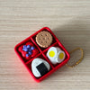 A red box contains various fidget items including a cake-shaped silicone piece, a wooden disc, and white silicone pieces.