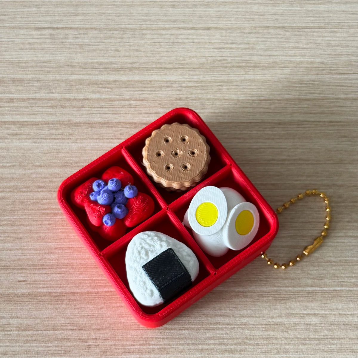 A red box contains various fidget items including a cake-shaped silicone piece, a wooden disc, and white silicone pieces.