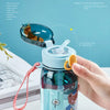 A hand opens a blue cartoon straw water bottle with an elastic cover for easy drinking.
