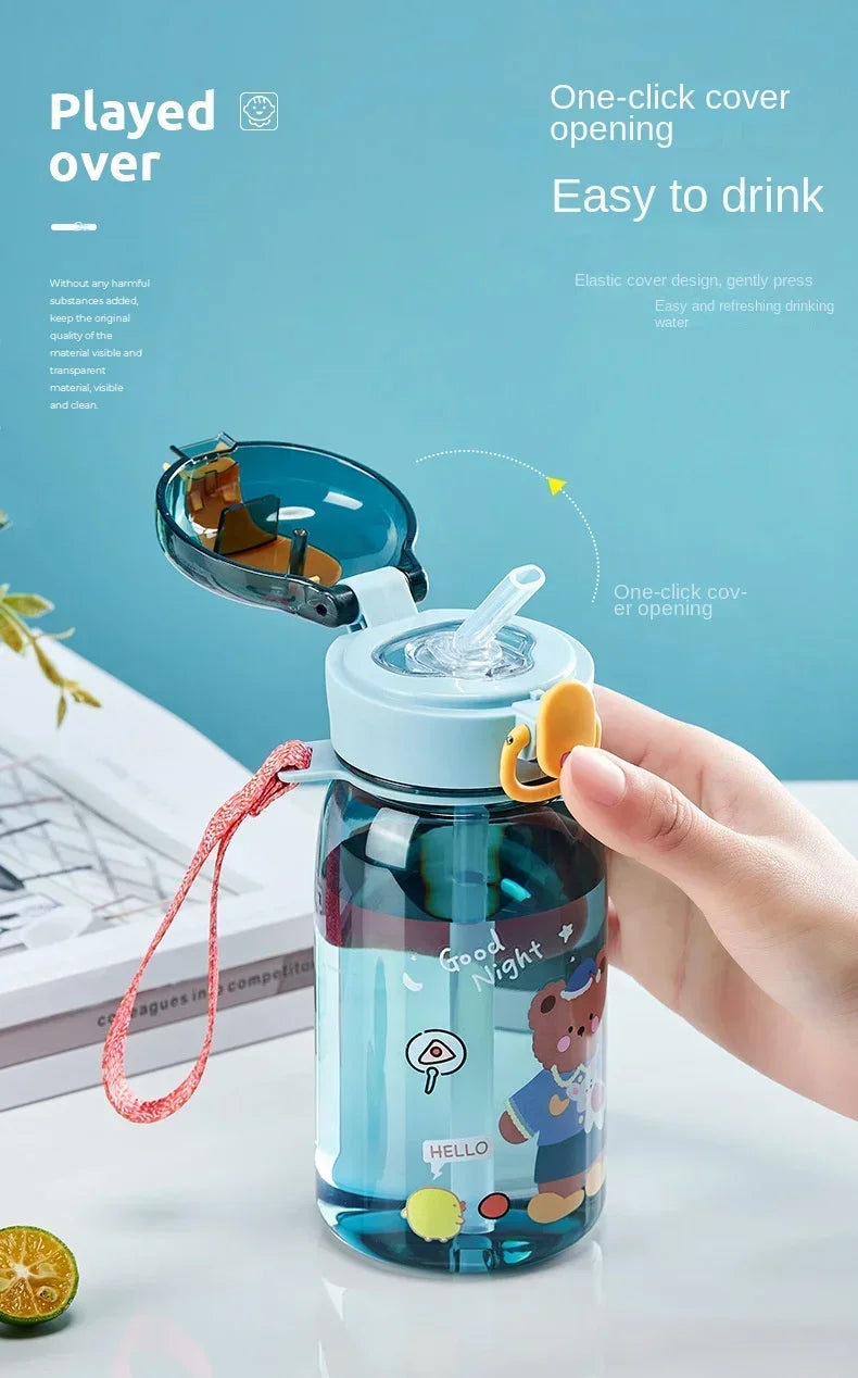 A hand opens a blue cartoon straw water bottle with an elastic cover for easy drinking.