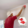 A person is using a red paint edger tool to apply paint to the corners and edges of a white wall.