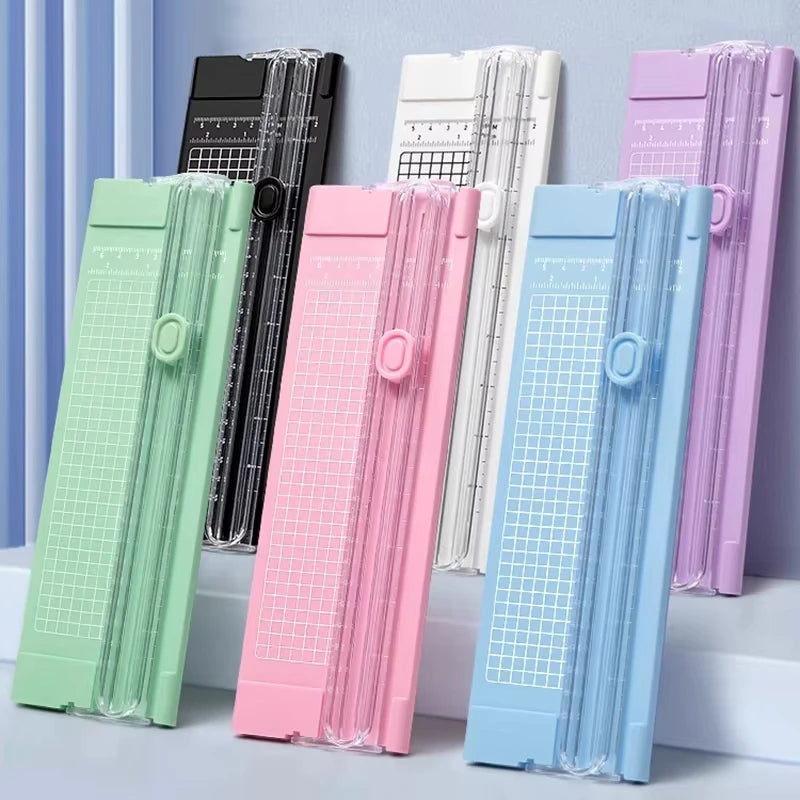 A collection of colorful A4 mini paper trimmers or cutters displayed in various shades including green, pink, white, and blue