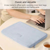 Bolsa interior de pana azul claro, usada como funda protectora para una laptop en un escritorio.