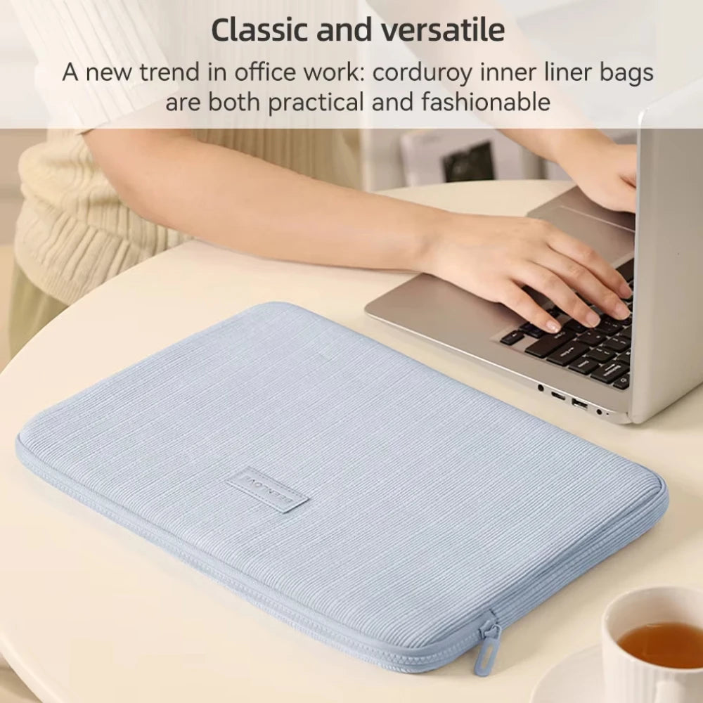 Bolsa interior de pana azul claro, usada como funda protectora para una laptop en un escritorio.