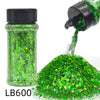 A green holographic chunky nail glitter mix in a jar with a black shaker top and a pile of loose glitter.