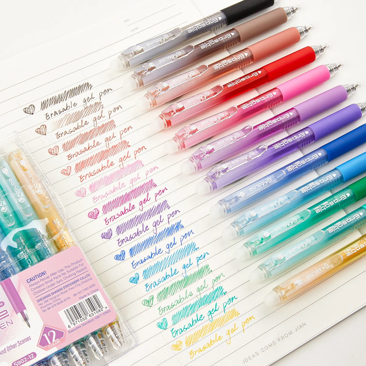 A collection of 12 retractable gel pens in various colors, including pink, red, purple, and green, laid out on a white sheet.