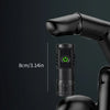 A close-up view of a mini black LED flashlight with a clip attached to a black glove hand.
