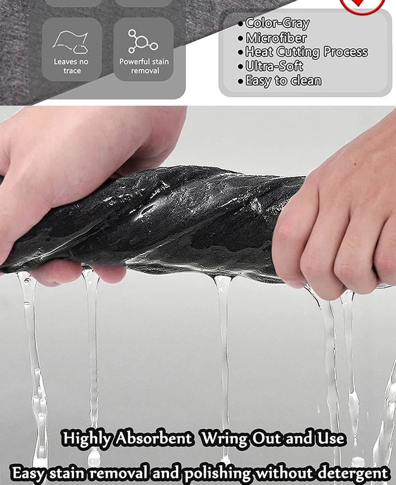 A hand is using a black microfiber cloth to wipe a surface, showing water dripping off the cloth.