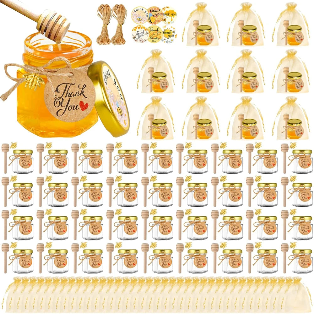 A collection of hexagon glass honey jars with wood dippers and bee pendants packaged in clear bags.