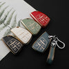 A collection of red and green TPU car key fobs with keychain attachments displayed on a dark surface.