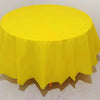 A bright yellow disposable round tablecloth is displayed on a table.
