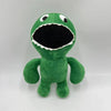 A green plush toy of an alien creature with a wide open mouth and large eyes.