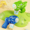 A green dinosaur bubble gun with lights and a blue dinosaur bubble gun on a green surface.