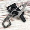 A compact fixed-blade neck knife with a black handle and silver blade is shown on a light wooden surface.