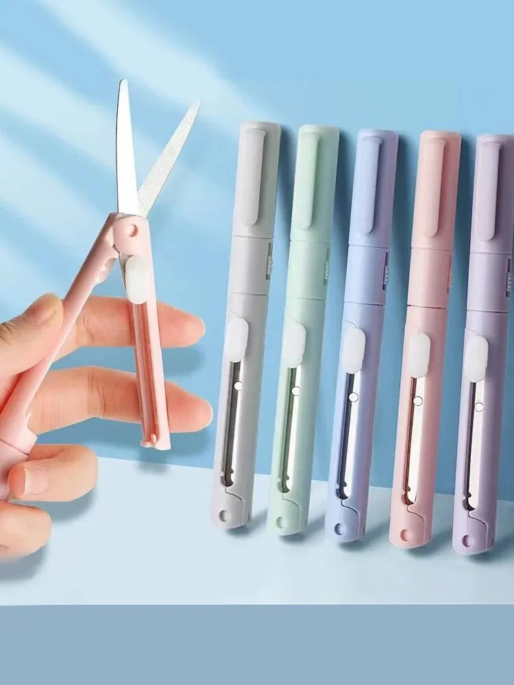 A hand holds a mini pen-shaped scissors and cutter tool with multiple color options.