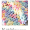 A close-up of multicolored fluffy chenille yarn in various pastel shades like pink, yellow, blue, and purple.