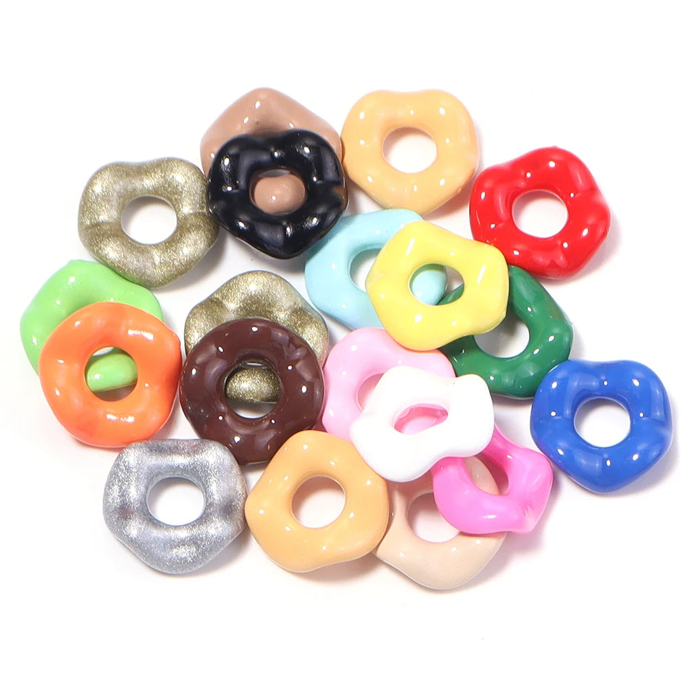 A collection of colorful acrylic spacer beads in a wave pattern, including gold, black, yellow, red, and various pastel shade