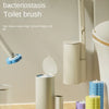 Wall-mounted toilet brush in beige and blue, shown next to a toilet and various refill containers.