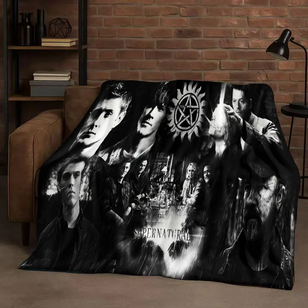 A dark flannel throw blanket featuring a collage of faces and symbols inspired by the Supernatural TV show.