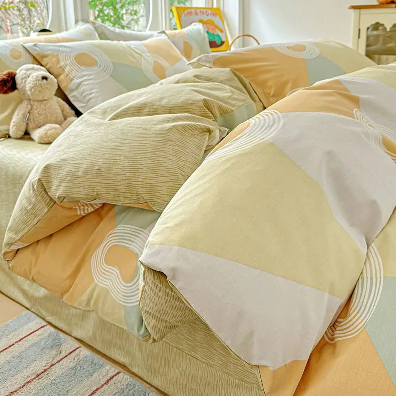 A set of beige and olive green cotton duvet covers and pillow shams with geometric patterns.