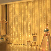 A sheer gold curtain decorated with vertical fairy lights, illuminating a room for home or party decor.