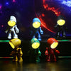 A collection of bendable robot night lights with soft yellow and orange glow against a cosmic background.