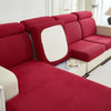 A deep red Jacquard stretch sofa slipcover with a white accent panel shown in a bright room.