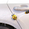 A yellow 3D cartoon bee door edge protector is shown spraying water onto a white car's door edge.