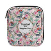 A pink floral crochet hook organizer bag with elastic loops and a white circle design.