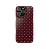 A dark maroon phone case for an iPhone featuring a pattern of small, light pink polka dots.
