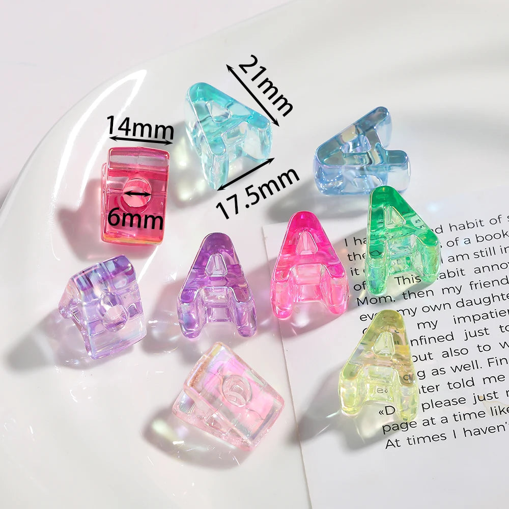 A collection of clear and colored acrylic alphabet beads displayed on a white plate.