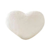 A soft, white heart-shaped plush throw pillow for cozy decor.