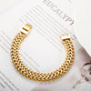 A chunky gold stainless steel link chain bracelet worn on a white background.