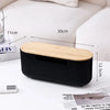 A black cable management box with a wooden lid is shown on a white desk surface.