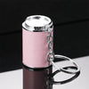 A silver metal coin tube keychain with a clear top is displayed on a reflective surface.