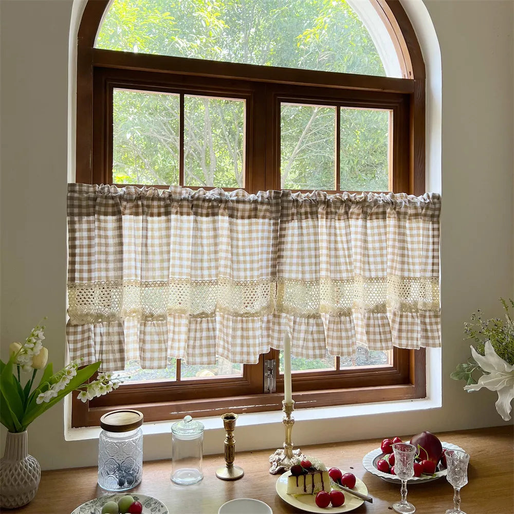 Beige gingham cafe curtain with crochet lace trim hanging in a wooden window frame.