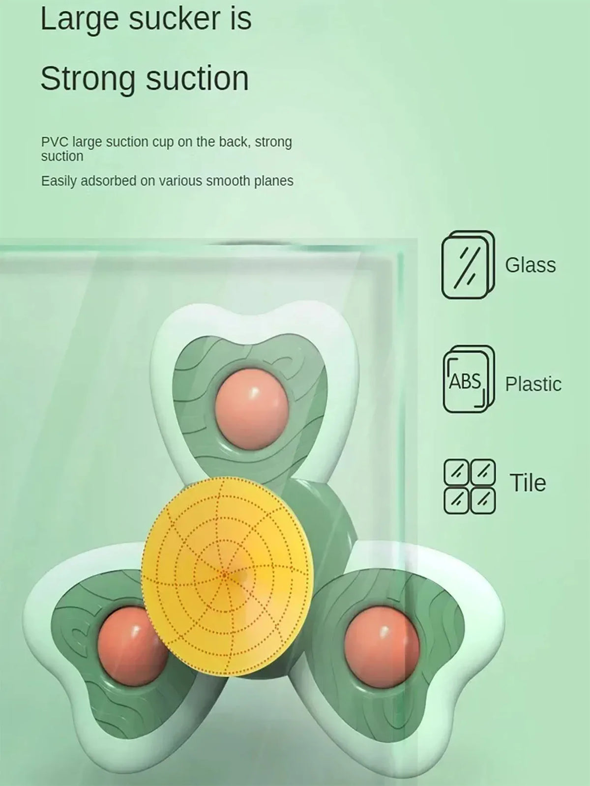 A large silicone suction cup bath toy shaped like an avocado, demonstrating a strong suction on various smooth surfaces.