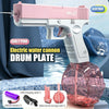 Pink electric water cannon toy gun with a drum plate and battery storage visible on a tiled surface.