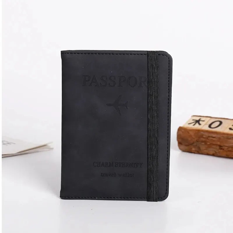 Black leather passport cover and travel wallet with a silver airplane emblem.