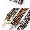 A close-up photo showing several leopard print wide adjustable crossbody bag straps in various shades and finishes.