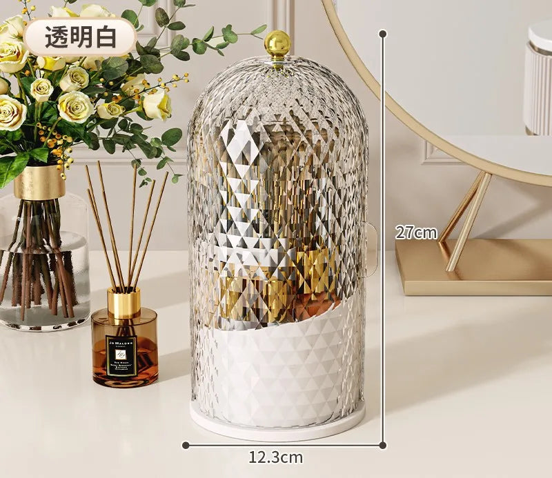 Organizador esférico transparente para brochas de maquillaje con tapa dorada y base blanca.