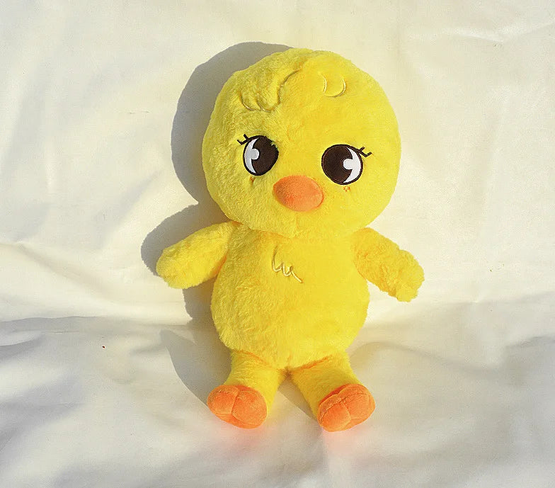 A yellow, fluffy plush toy resembling a chick or small animal with large eyes and orange feet.