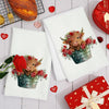 A set of two white kitchen towels featuring a watercolor illustration of a Highland cow in a floral planter.