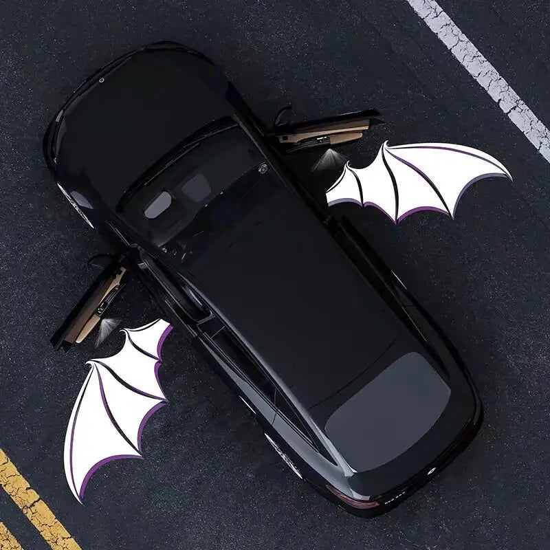 A black Toyota 4Runner is shown with white bat-shaped LED door logos and a light projector on the hood.